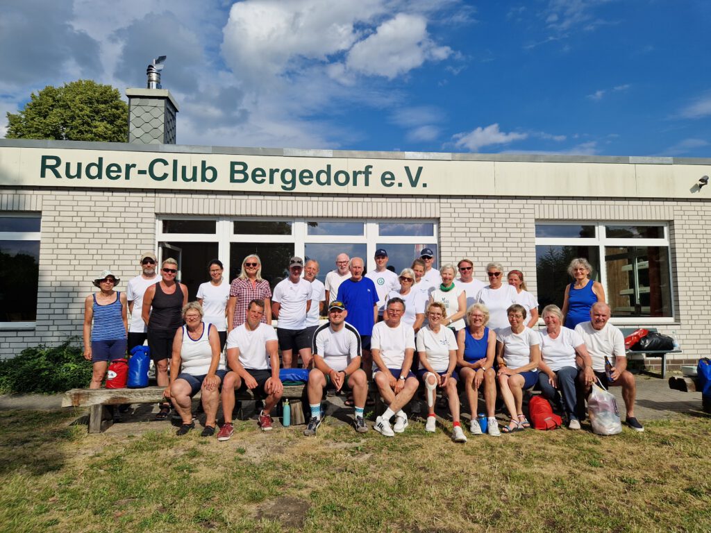 Gruppenfoto einer größeren Personengruppe in Sportkleidung vor dem Gebäude des Ruder-Clubs Bergedorf